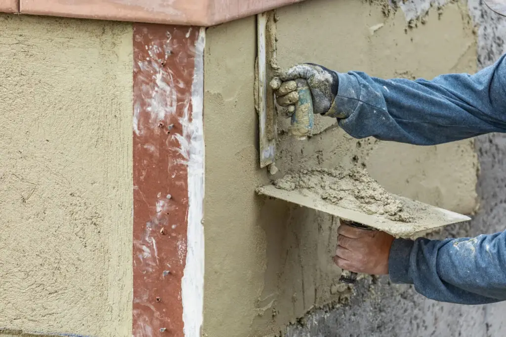Contractor applying stucco to repair damaged residential wall in Lakeland, FL.