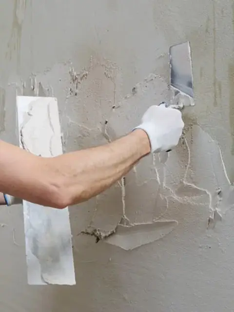Worker applying fresh stucco patch during exterior wall repair in Lakeland, FL.
